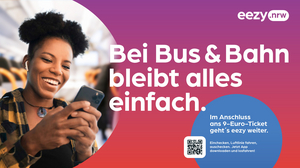 Plakat einer Kampagne zu eezy.nrw. Zusehen ist eine junge Frau, die in einem Zug steht und ein Handy in der Hand hält. Daneben steht "Bei Bus & Bahn bleibt alles einfach".
